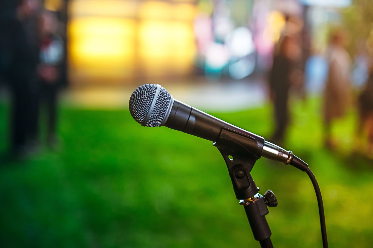 picture of an open microphone against a green and yellow background
