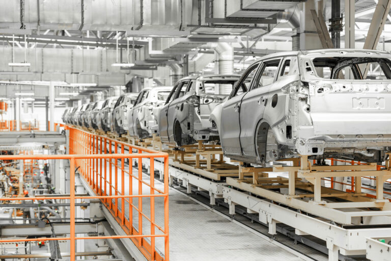 line cars on manufacturing row in early stage with no employees around