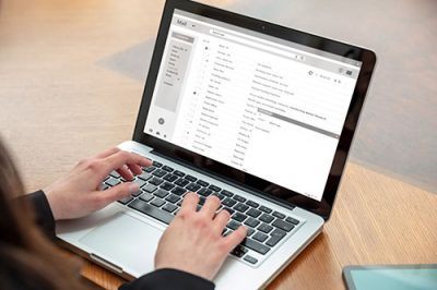 Email client list, woman hand on the computer laptop, inbox e ma Email client list, woman working with a computer laptop, inbox e mail messages on the screen, business office desk background